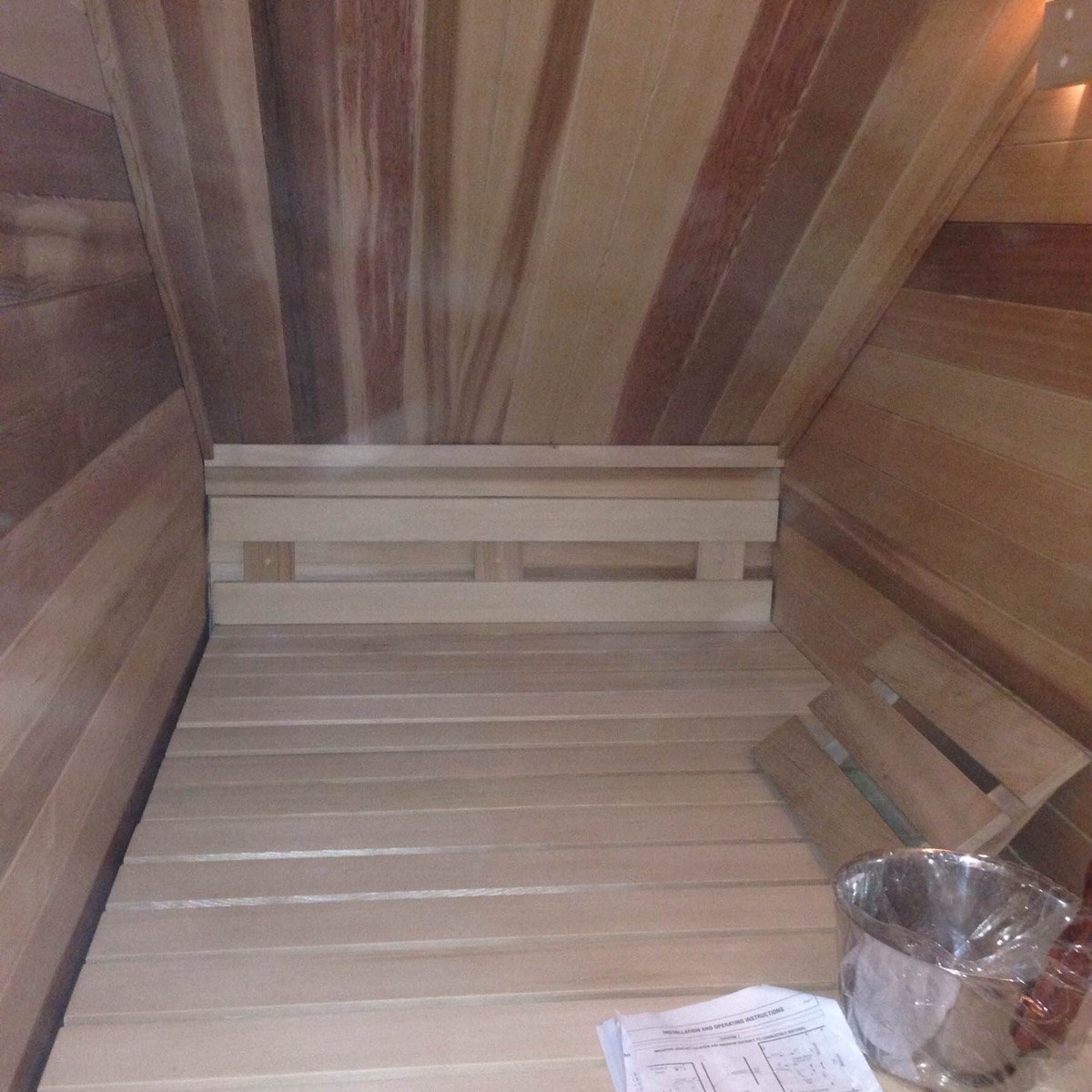 Wall-mounted sauna thermometer with cedar benches
